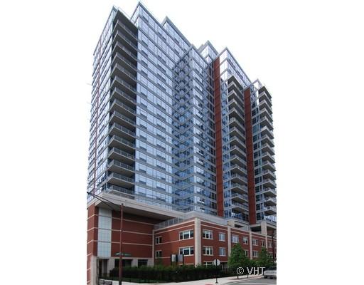 Front view of a multi-story residential building with glass and brick facade.
