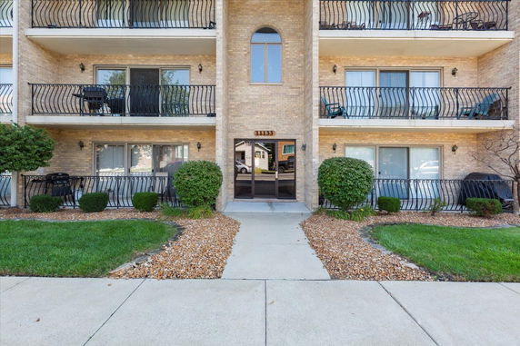 Front view of a multi-story brick building with balconies.