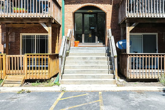 Front view of a brick building with stairs leading to the entrance.