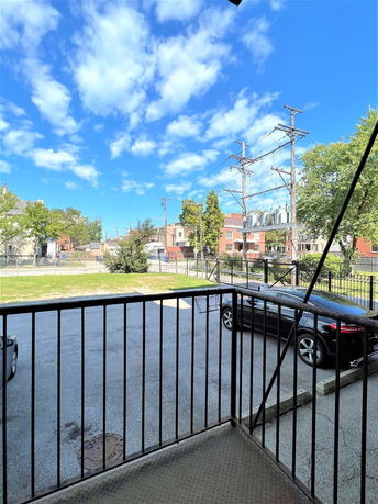 View of an outdoor parking area with a car parked near a metal railing.