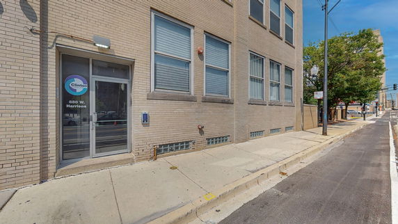 Front view of a brick building with multiple windows and a glass door entrance.
