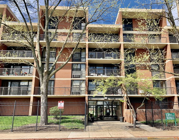 Front view of a multi-story apartment building with balconies.