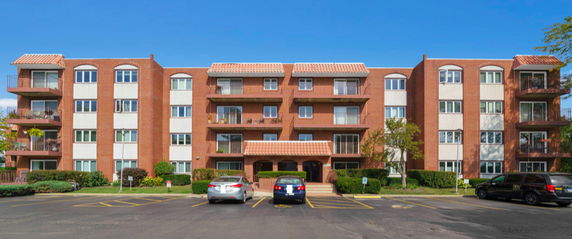 Front view of a multi-story apartment building with balconies.