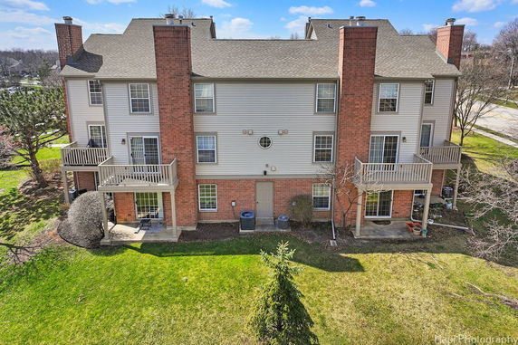Rear view of a multi-story residential building with balconies and brick exterior.