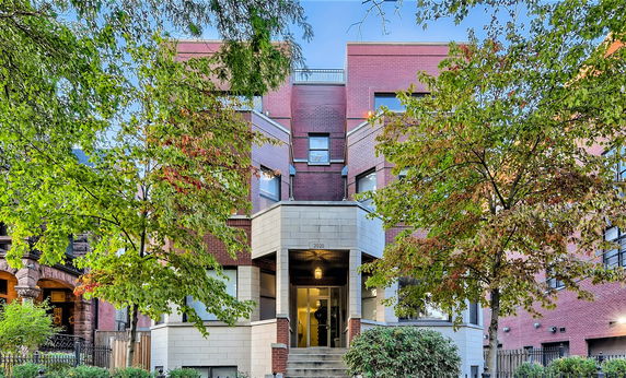 Front view of a multi-story building with a brick exterior and central entrance.