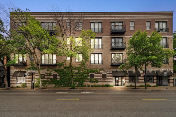Front view of a multi-story apartment building with balconies.
