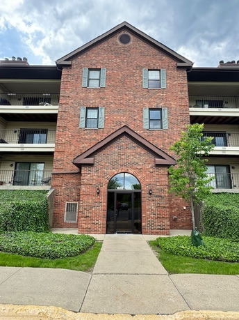 Front view of a multi-story brick building with balconies.