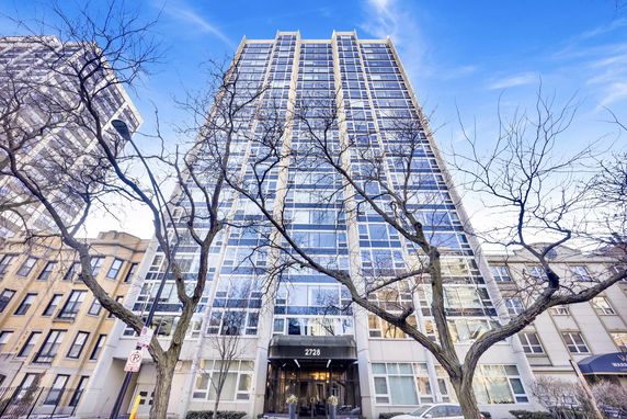 Front view of a high-rise building with large glass windows.