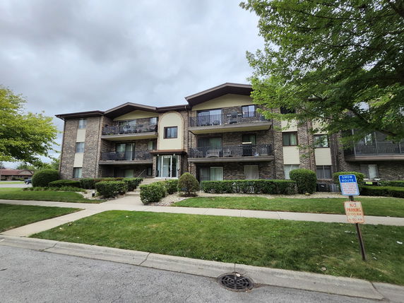 Front view of a multi-story residential building with balconies.