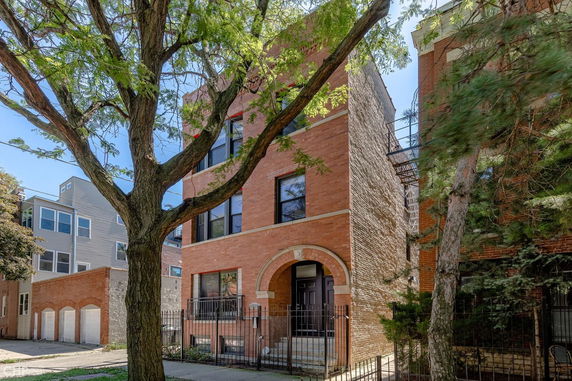 Front view of a multi-story brick building with an arched entrance.