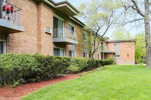 Front view of a brick apartment building with balconies.