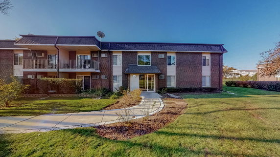 Front view of a two-story building with balconies and a central entrance.