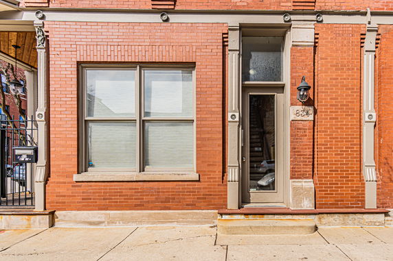 Front view of a brick building with a door and window.