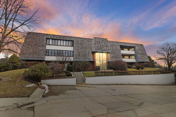 Front view of a multi-story building with a unique sloped roof design.
