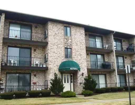 Front view of a three-story apartment building with balconies.