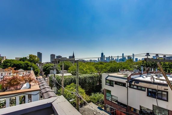 Panoramic cityscape view with buildings and trees in the foreground.