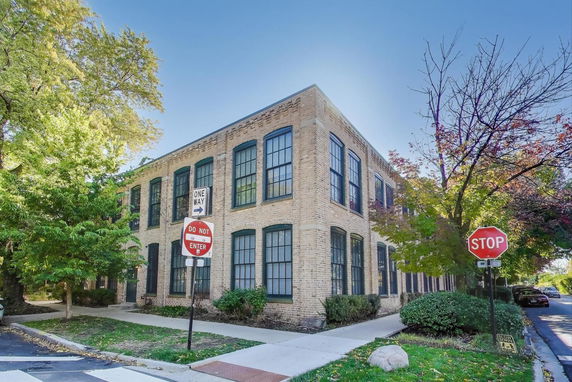 Front view of a two-story brick building with large windows.