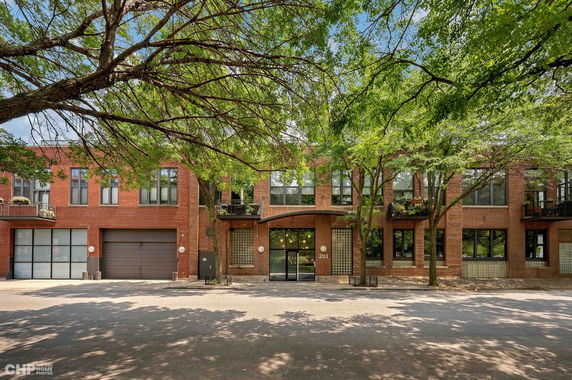 Front view of a two-story brick building with large windows and garage doors.