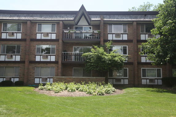 Front view of a three-story apartment building with balconies.
