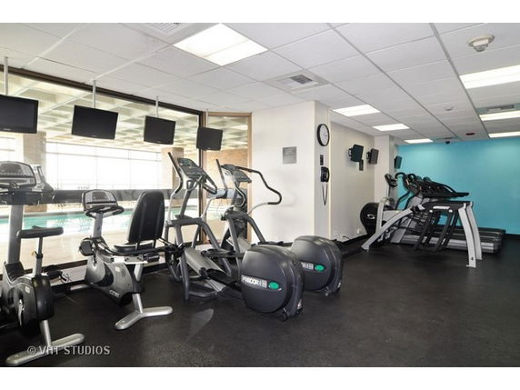 Gym area with exercise equipment and large windows.