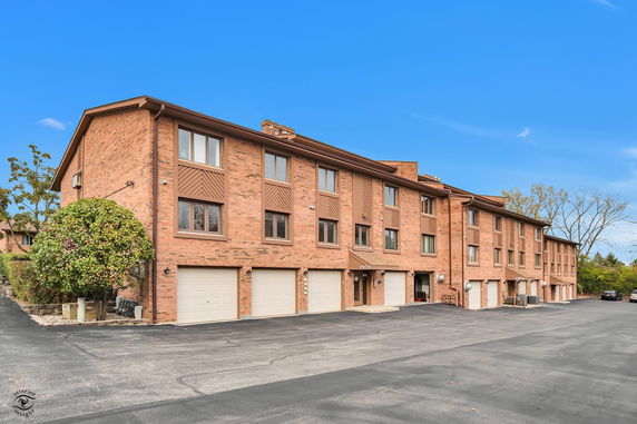 Front view of a multi-story brick building with garages.