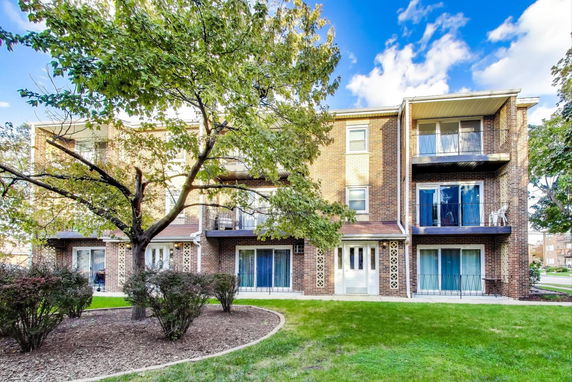 Front view of a multi-story brick building with balconies.