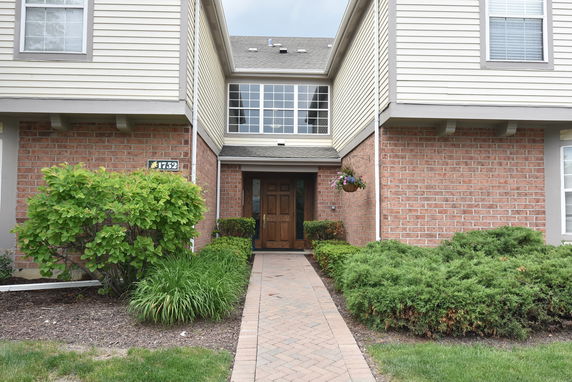 Front view of a two-story house with brick and siding exterior.