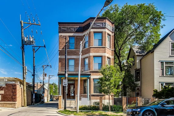 Front view of a multi-story brick building with a bay window design.