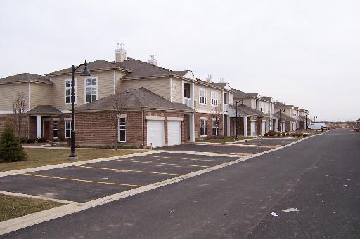 Front view of a row of modern two-story townhouses with garages.