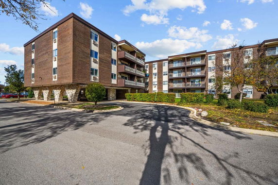 Front view of a multi-story apartment building with balconies.