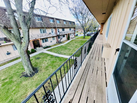 View from a building of a courtyard with pathways and trees, surrounded by multi-story residential buildings.