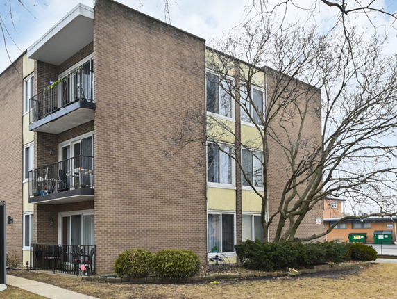 Front view of a multi-story apartment building with balconies.