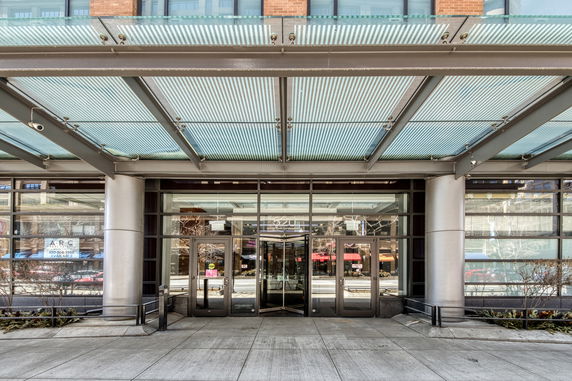 Front view of a commercial building with glass entrance and metal canopy.
