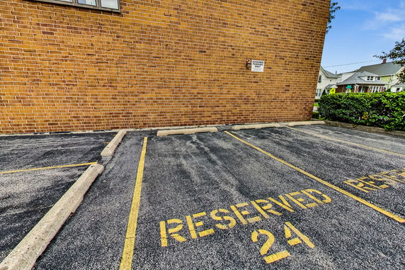 Outdoor reserved parking spaces against a brick building wall
