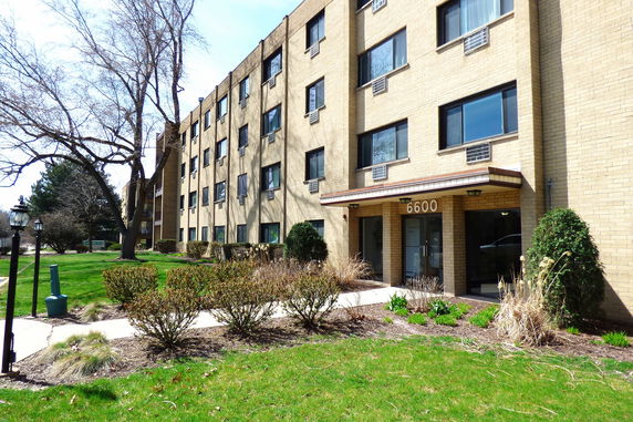 Front view of a multi-story brick building with a main entrance.
