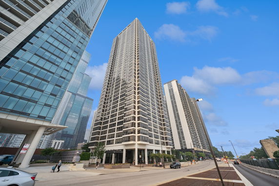 Front view of a tall apartment building with multiple balconies.