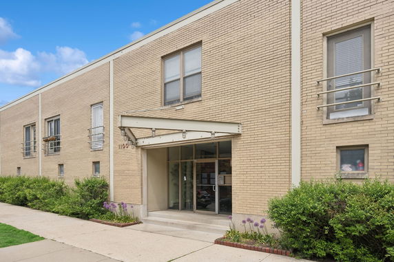 Front view of a two-story brick building with multiple windows and a glass entrance.