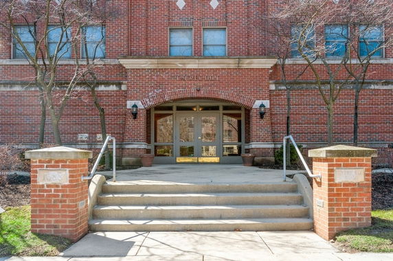 Front view of a brick building with steps leading to the entrance.