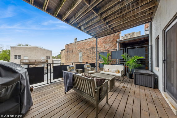 Rooftop patio with outdoor seating and a covered grill area.