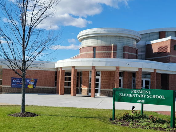 Front view of an elementary school building with a brick facade and rounded architectural elements.