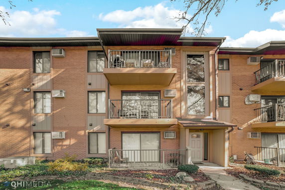 Front view of a multi-story apartment building with balconies.