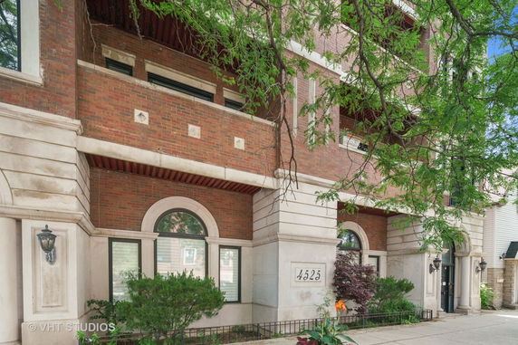 Front view of a brick multi-story building with large windows and architectural details.
