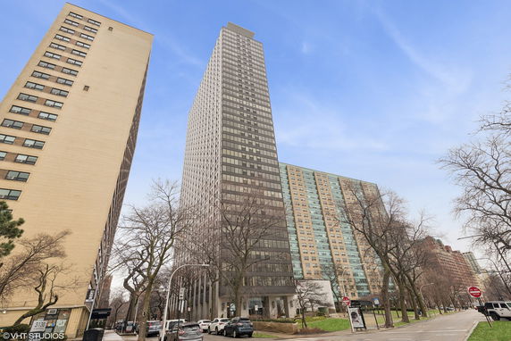 Front view of a tall apartment building with numerous windows.