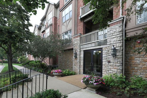 Front view of a multi-story building with stone and brick facade, entrance with number 1739.