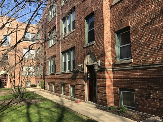Front view of a multi-story brick apartment building.