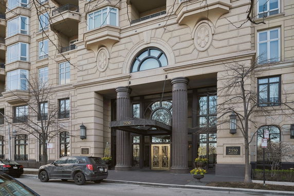 Front view of a multi-story building with decorative columns and large windows.