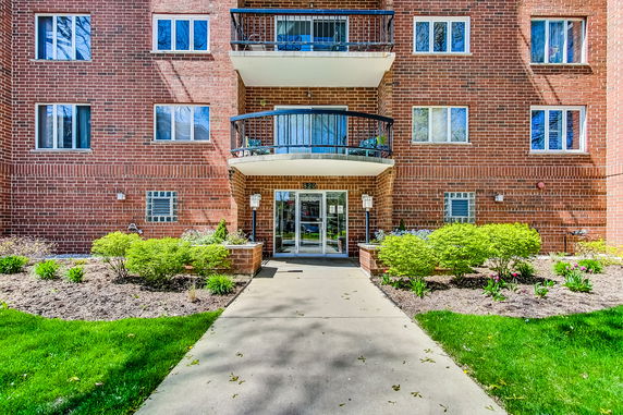 Front view of a multi-story brick building with balconies.
