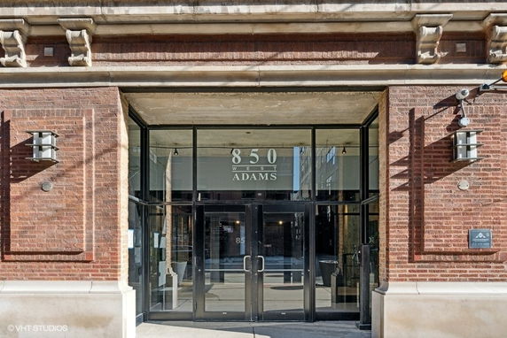 Front view of a building entrance with glass doors and brick exterior.