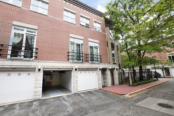 Front view of a multi-story townhouse with multiple garage doors.