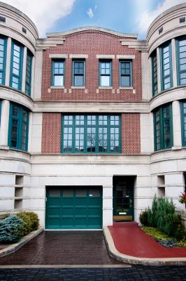 Front view of a multi-story building with a brick facade and green framed windows.